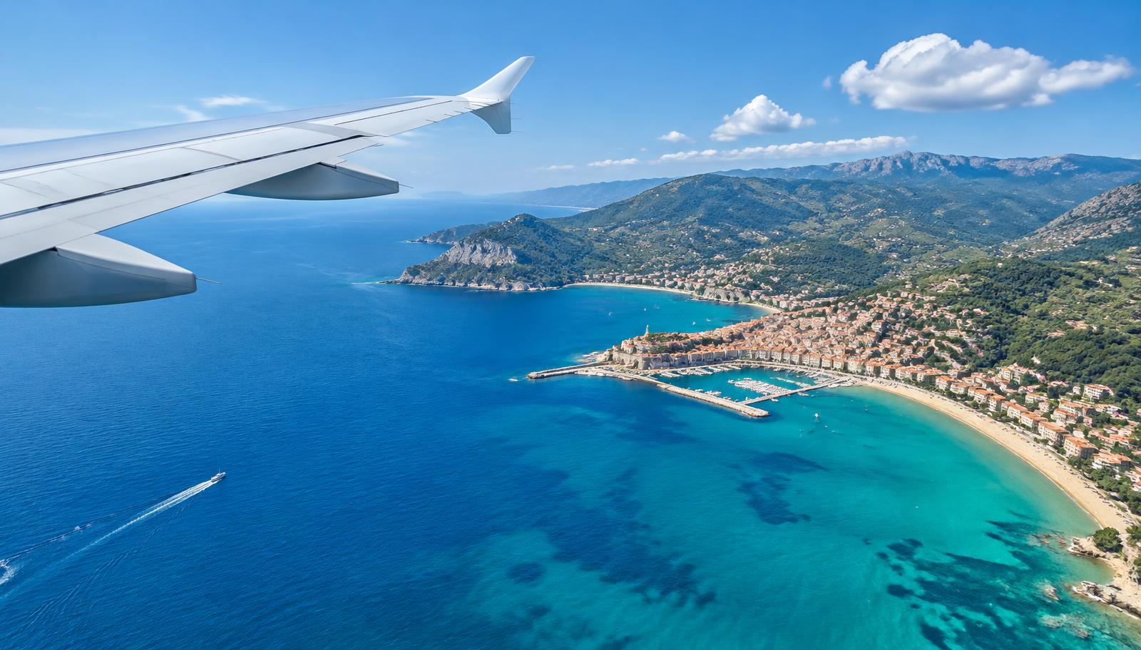 An aircraft wing above the Mediterranean coastline